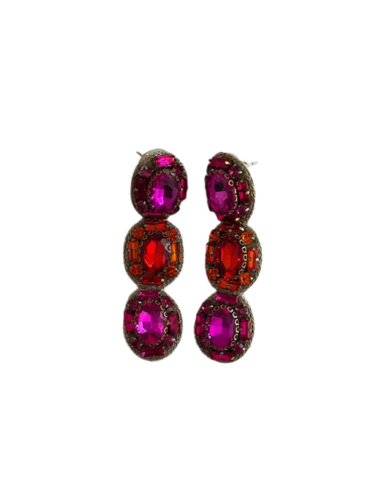 Pair of earrings with red and orange gemstones on a light gray background