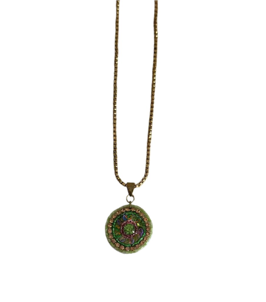 Necklace with a round pendant on a plain background