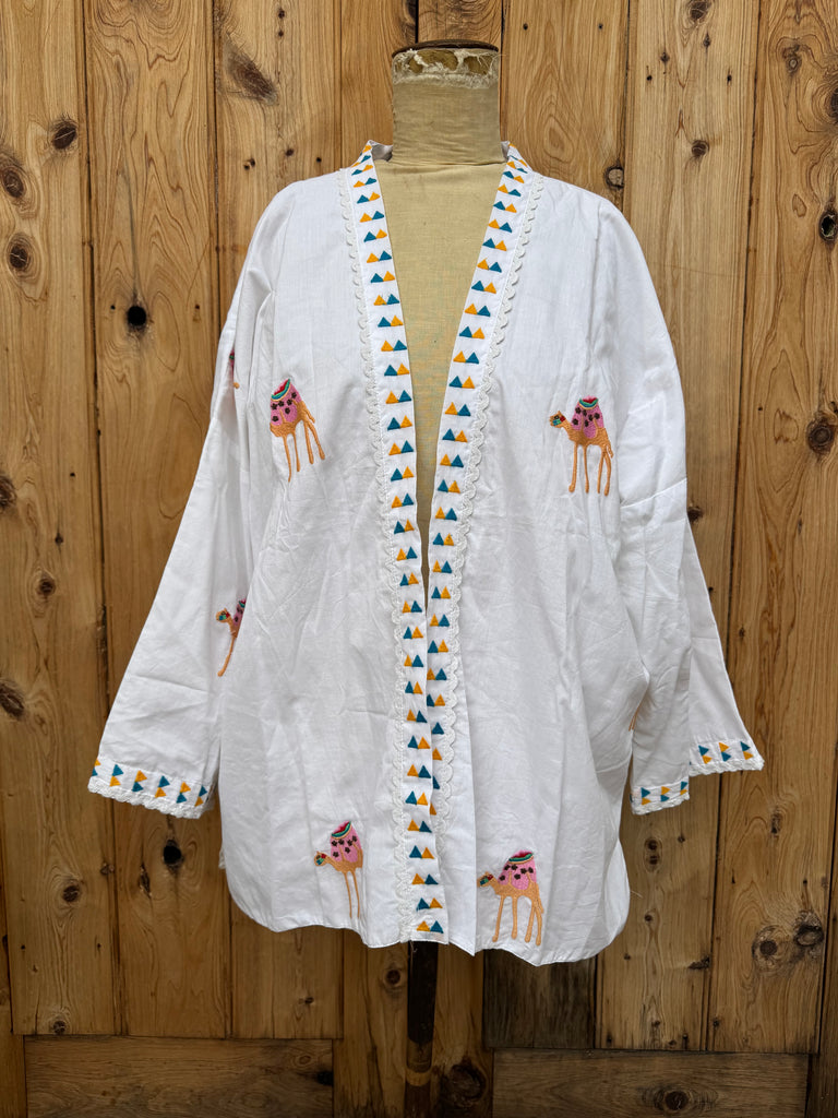 White embroidered garment on a wooden surface