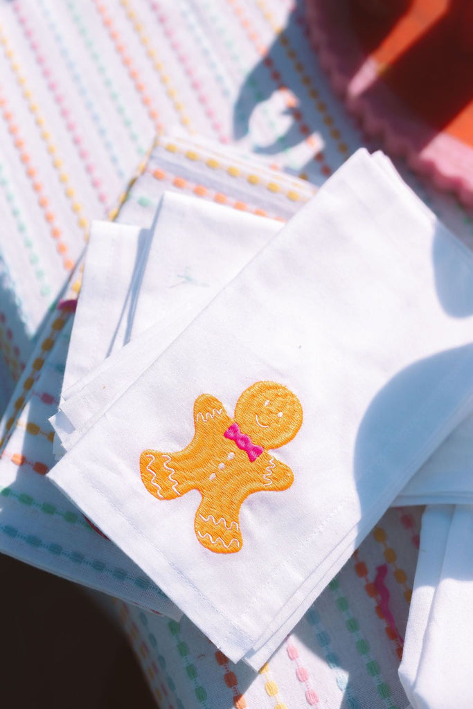 Stack of colorful fabric squares with a gingerbread man design on one of them.