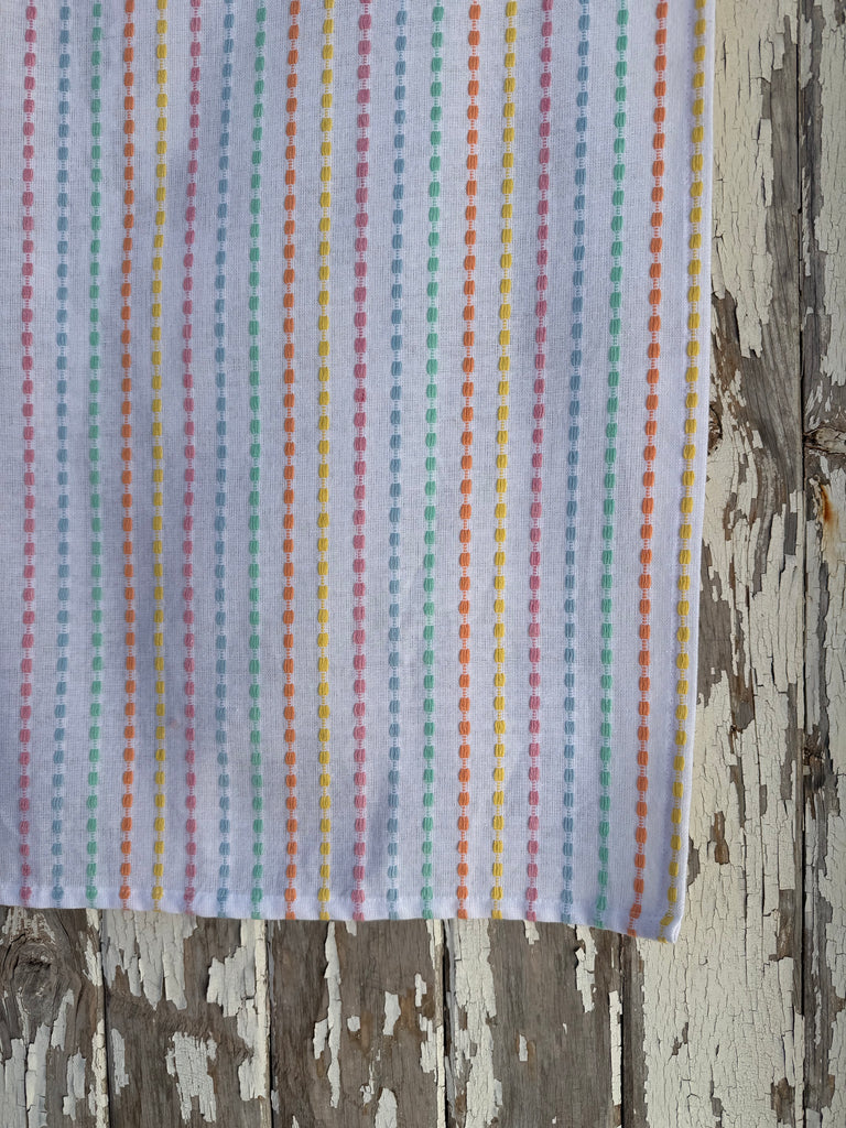 Striped fabric with multicolor pattern on a wooden surface