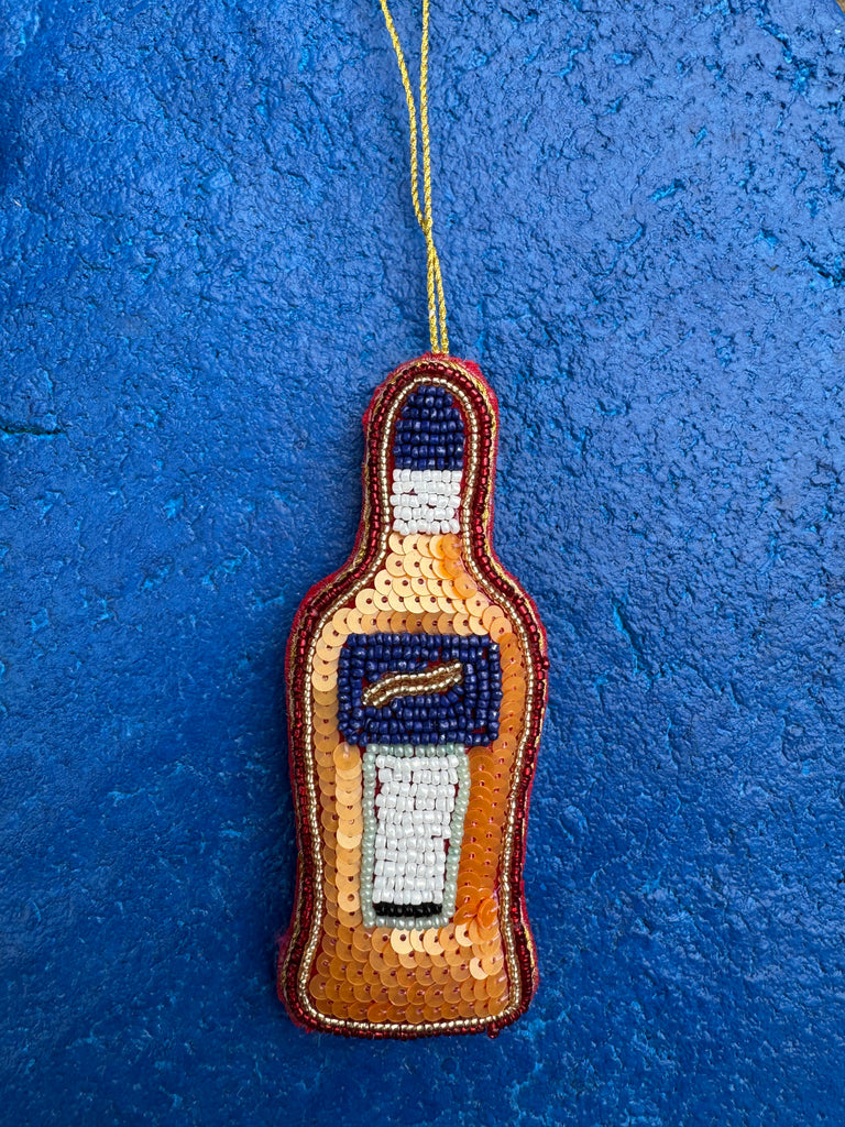 Beaded bottle-shaped ornament on a blue textured background