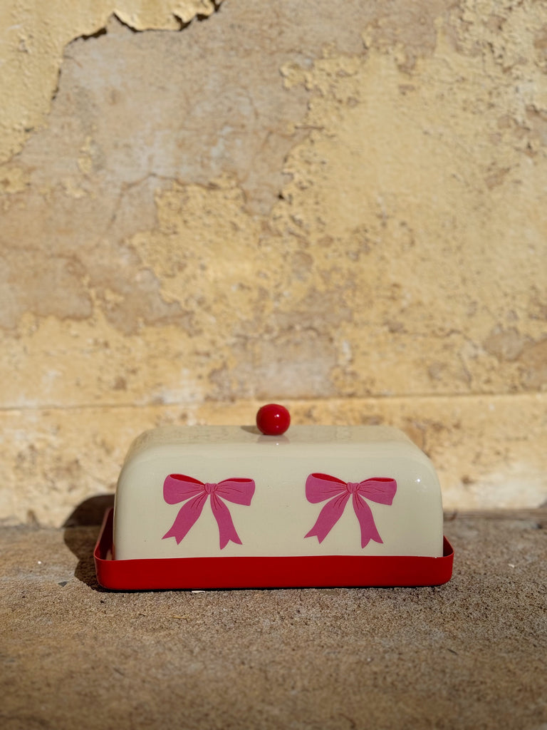 butter dish with pink and red bows against wall