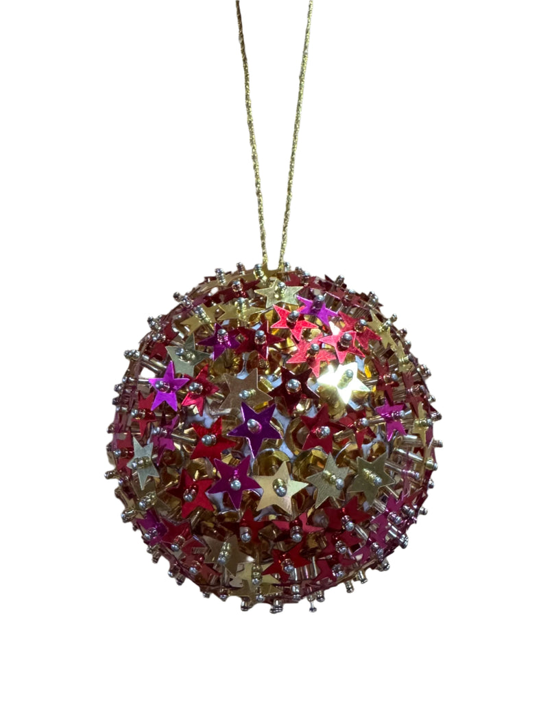 Decorative spherical ornament with star-shaped beads on a wooden surface