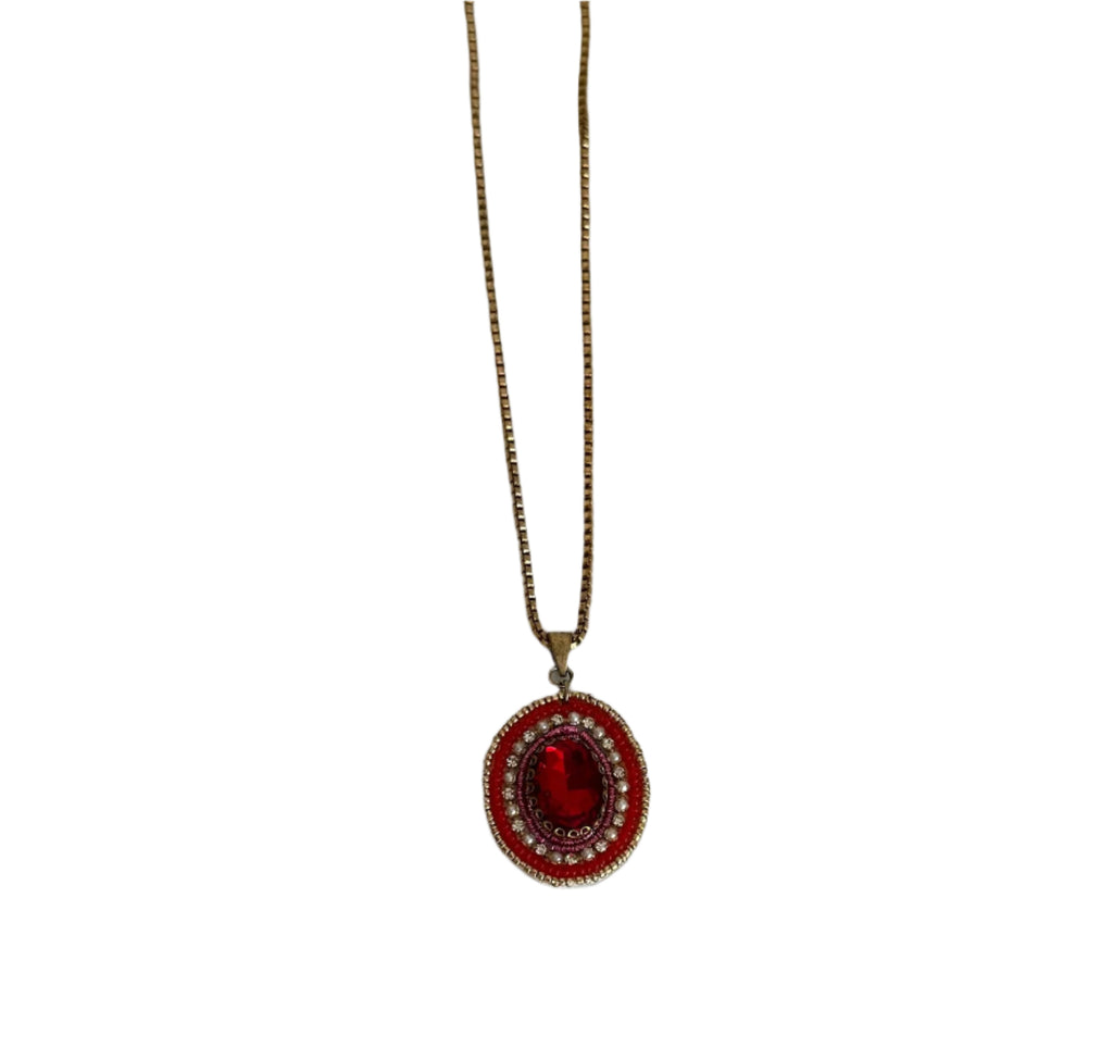 Necklace with a red pendant on a plain background