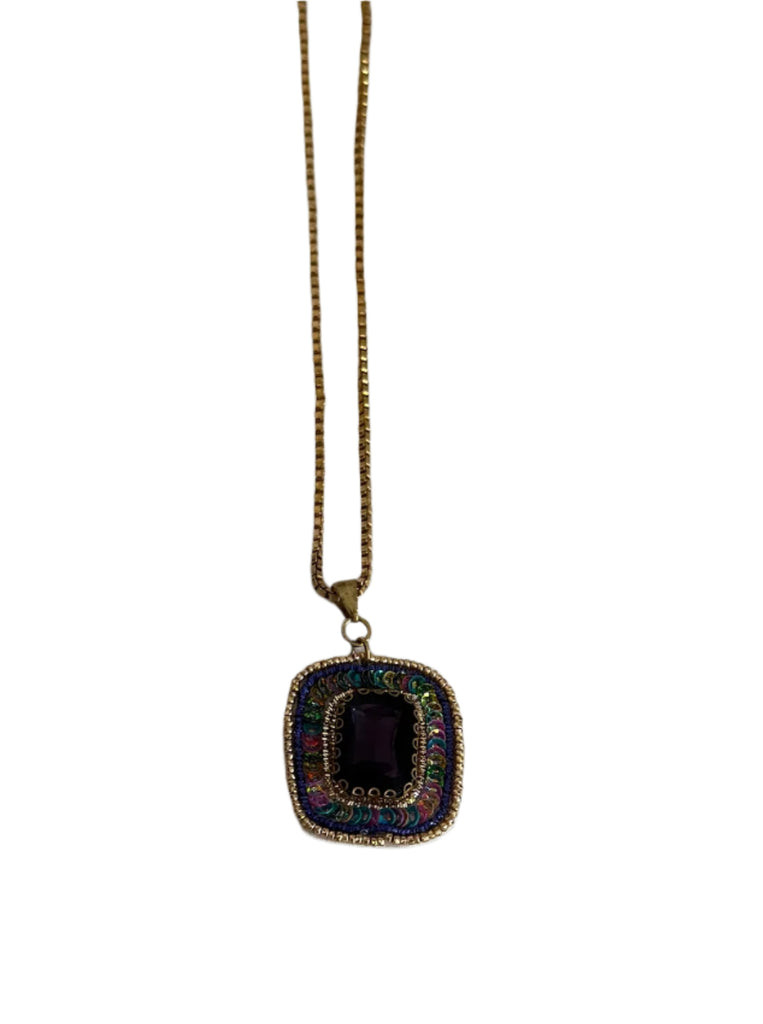 Necklace with a square pendant on a plain background