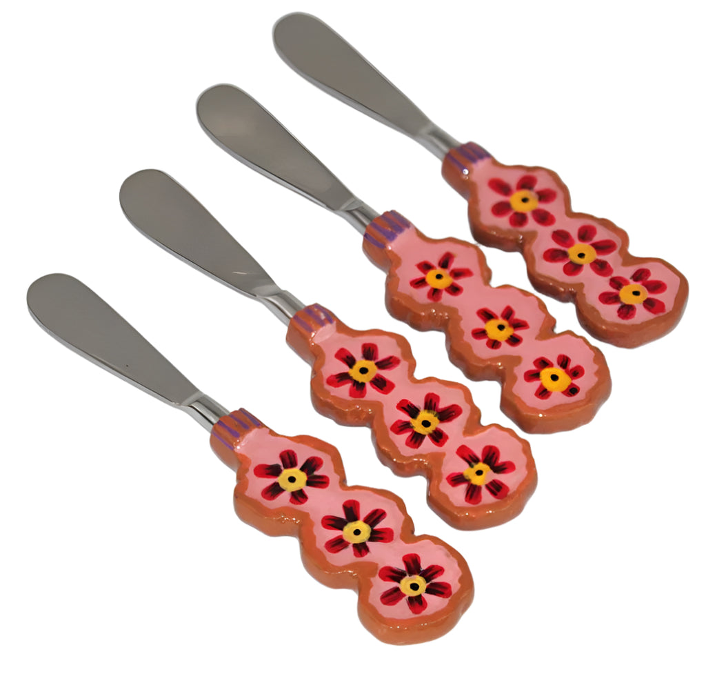 Set of four floral-patterned butter knives on a white background